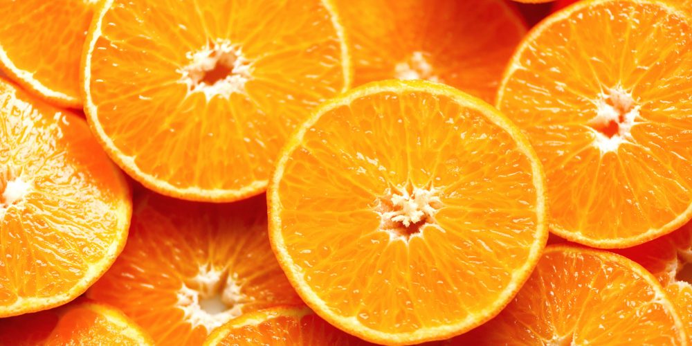 Fresh sliced orange fruit texture. Macro, top view, copy space. Food frame. Juicy oranges background.